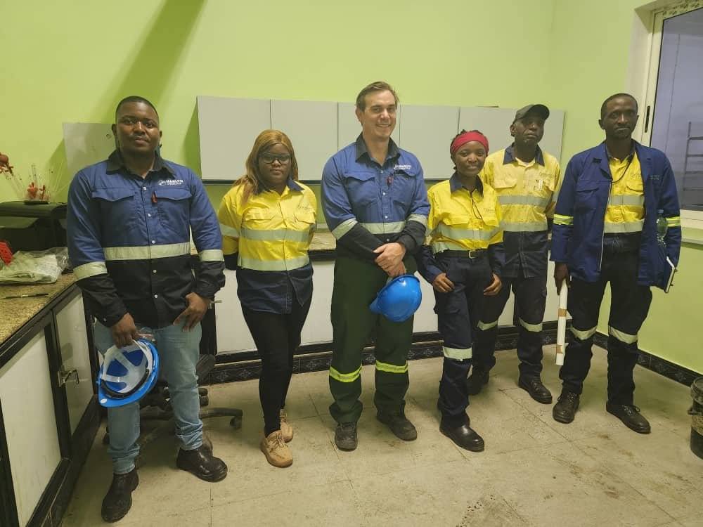 Cortex Consult team members in blue and yellow workwear, standing in a workshop in Kolwezi